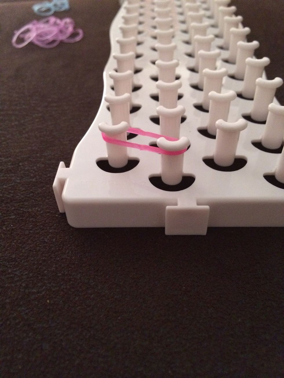 First make sure all your pegs are facing up (so they look like a U) Add your first loom to your first peg and the one diagonal to it
