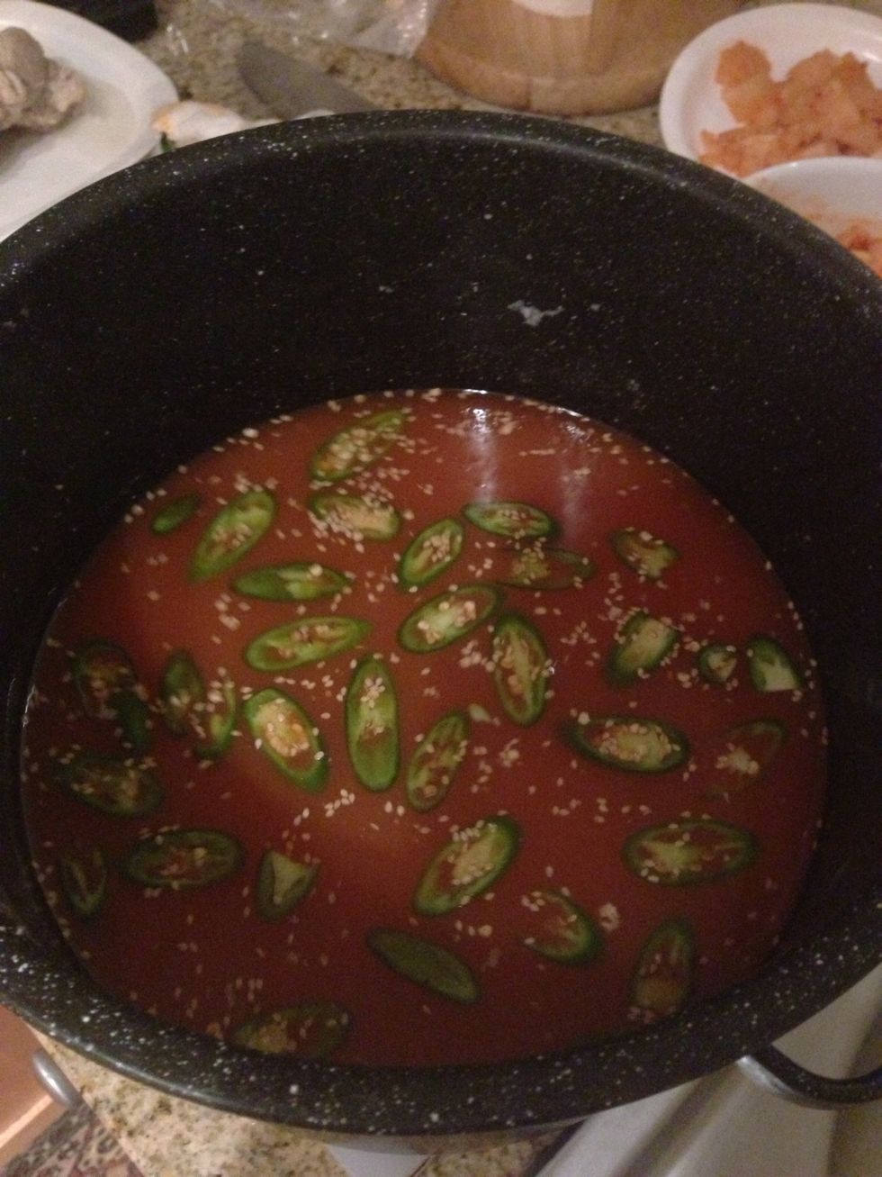 First, make the broth and chill. Cold salted pork broth with all fat removed, add kimchi broth and memmi soy sauce with sesame seeds. Add sugar and rice vinegar to taste.