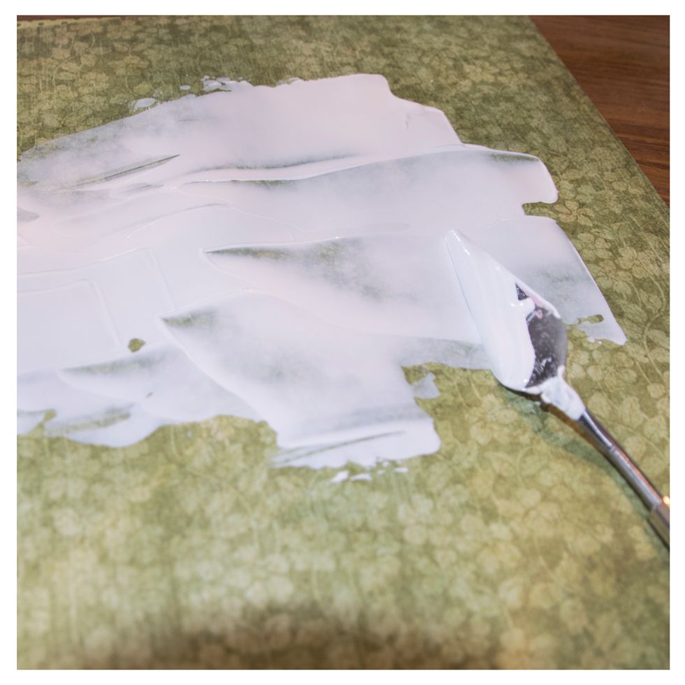 First of all I use a pallette knife to add a layer of gesso on the background paper.