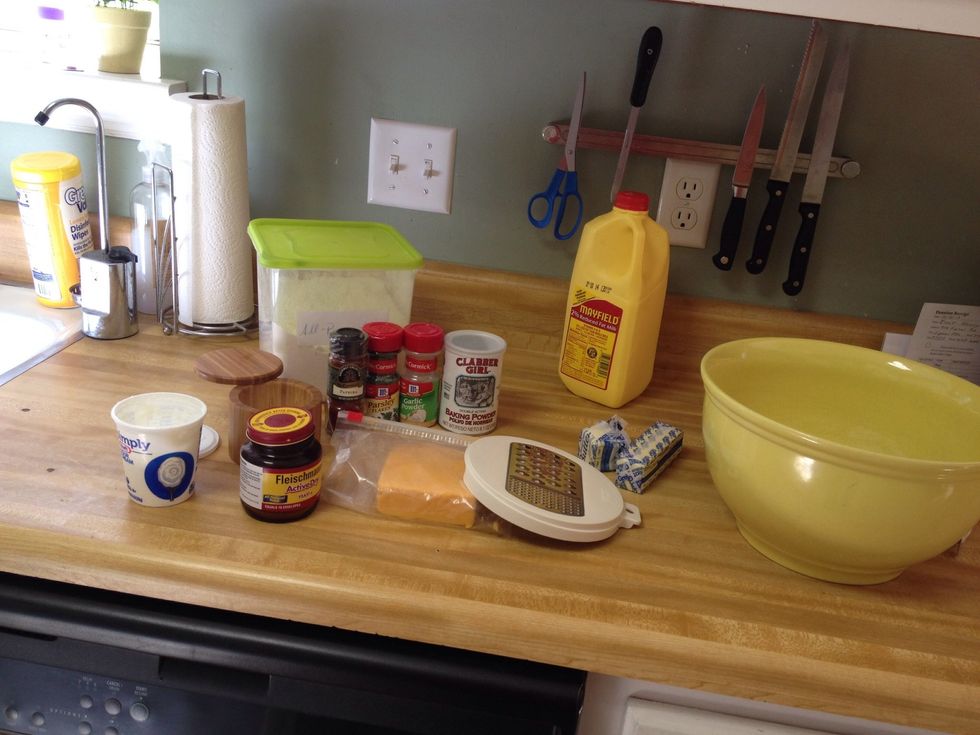 First off, place yeast in warm milk. Stir and let sit. Measure your flour. Don't forget to stir the flour in your container first. This will make your biscuits much lighter. Preheat oven to 400.