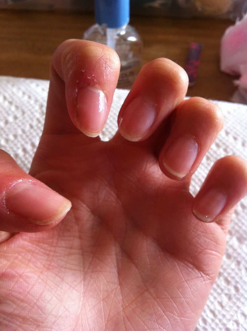 First, paint a clear base coat over clean nails. (This step is optional, but the base coat prevents any staining of the nail.)