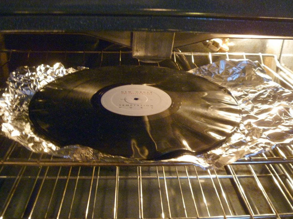 First, per-heat the oven. (In my case, it is about 350F) Then, put your vinyl record in the oven just like what you would do for baking pizza. In a minute or so, the record will become very soft.