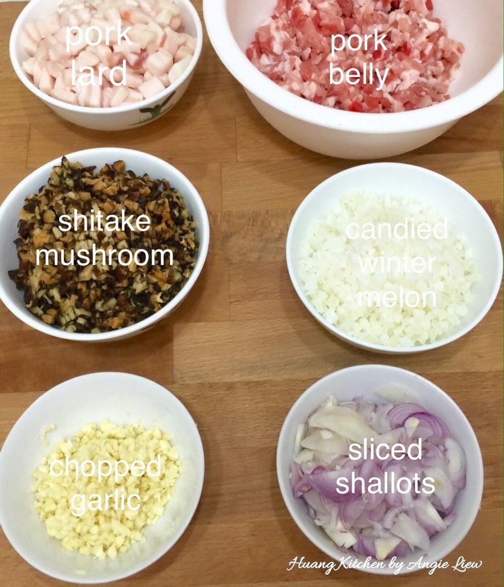 First prepare the filling. So finely chopped garlic and shallots. Wash, drained well and cut pork and pork fats into small pieces. Dice soaked mushrooms & candied winter melon into small pieces.