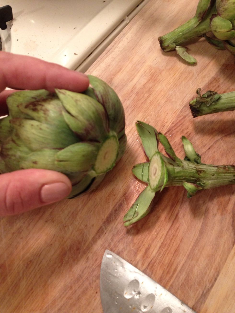 First prepare your artichoke by cutting off stem...