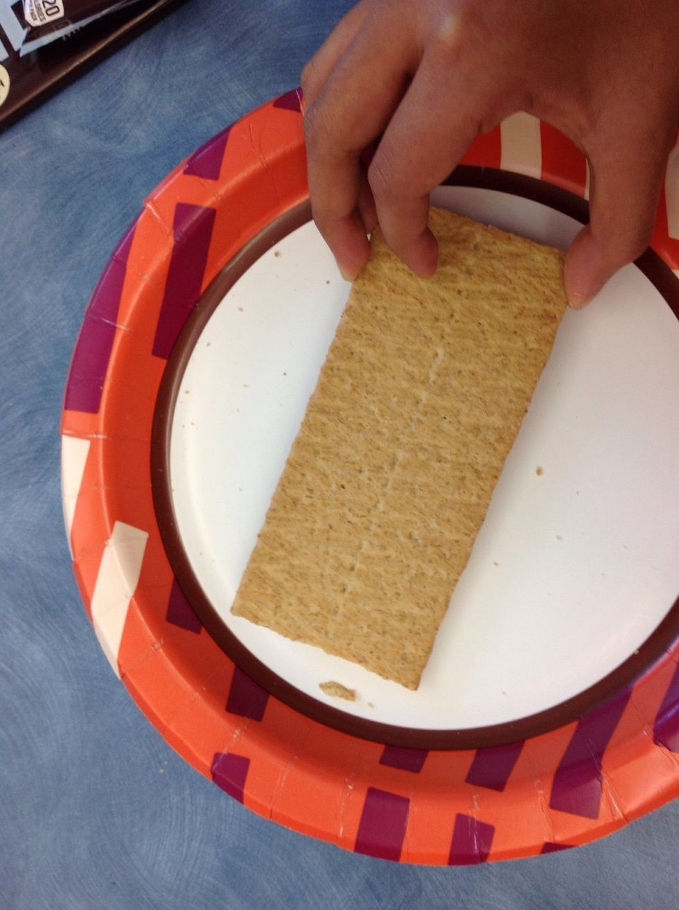 First' put a graham crackeron the plate.