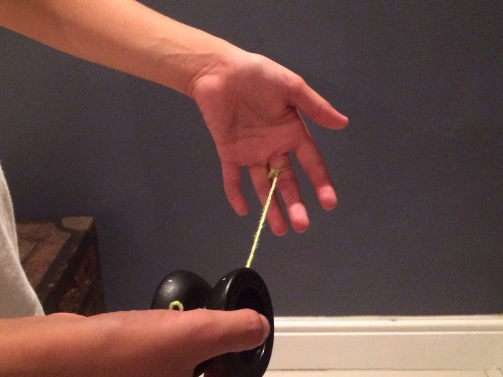 First put your middle finger through the hole of the string which has been made already