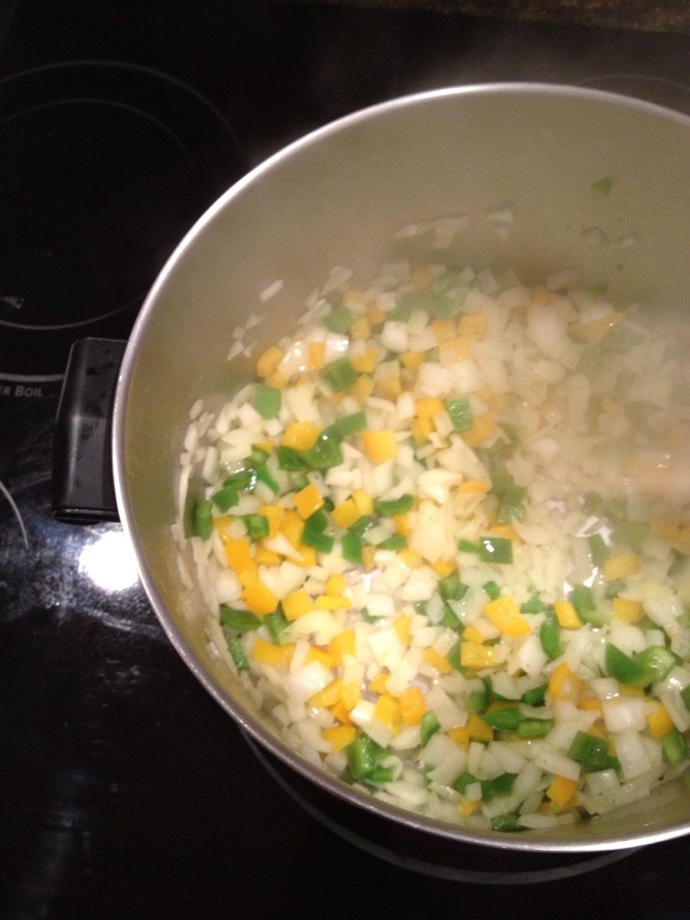 First saut\u00e9 onions and peppers in oil for 5 minutes in a large pot.