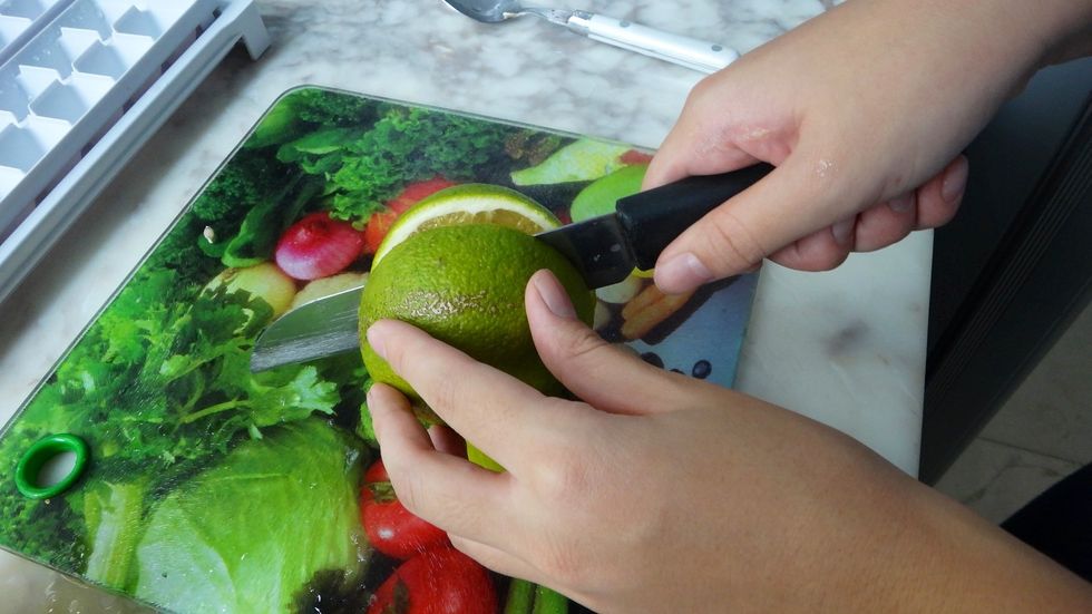 First, slice the oranges in half.
