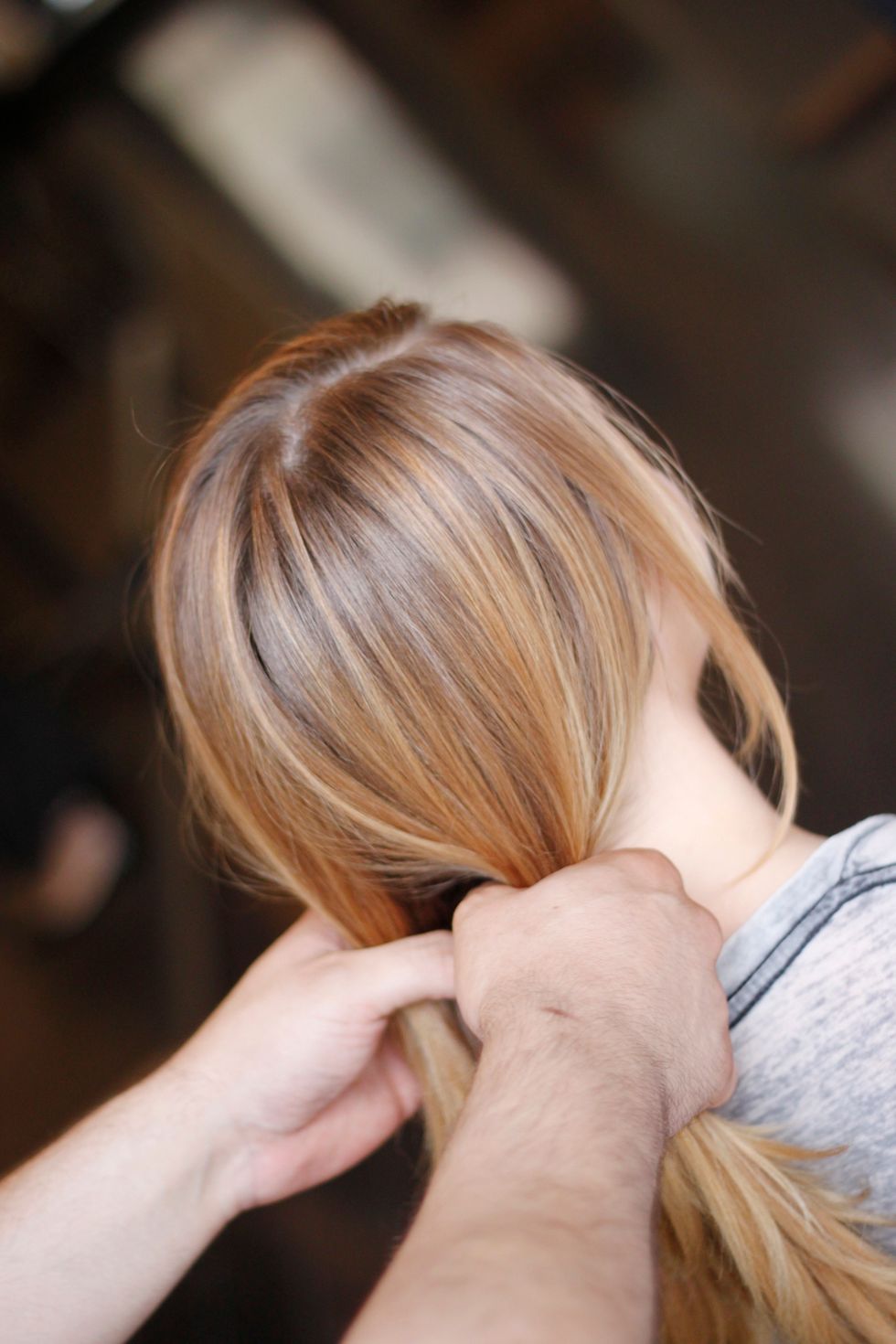 First, spray hair with a texturizing spray to make it easier to work with. Then let the hair part and fall naturally. Gather hair into two ponies, letting some front pieces fall out to frame the face