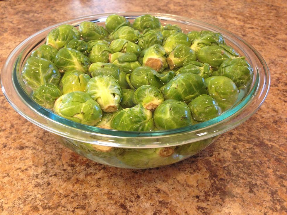 First, start by washing the Brussels sprouts. Then soak them in cold water 20-30 minutes. This recipe can be adjusted to whatever size you need. I usually use 3-4 lbs of Brussels sprouts to feed 4-6.