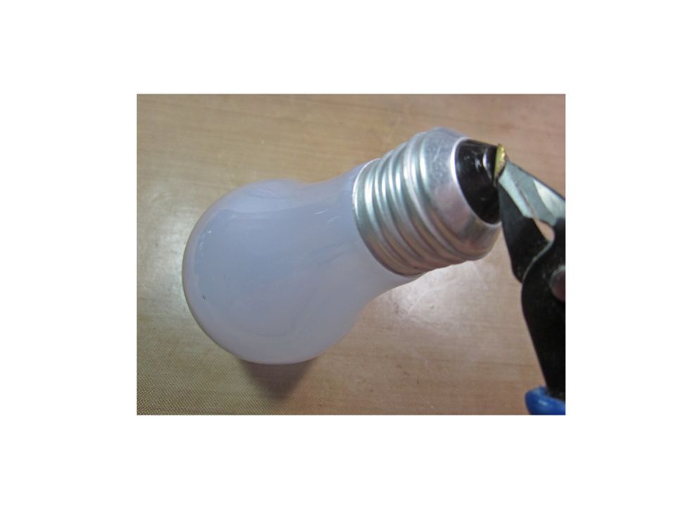 First step is take a pair of pliers and peel off the metal tab on the bottom of the used light blub. Be sure to wear eye goggles during the process of preparing the blub.