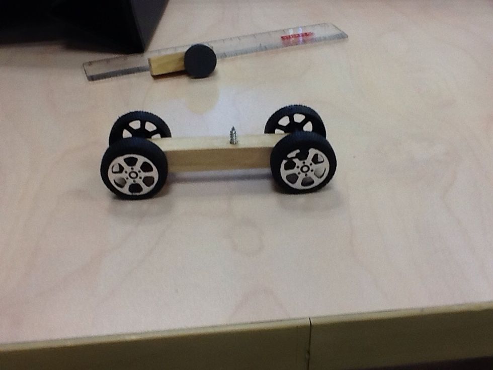 First,stuck the rods on the 2 ends on the piece of wood thats 8cm,then,put the wheels on the rod after,put the nail in the middle.