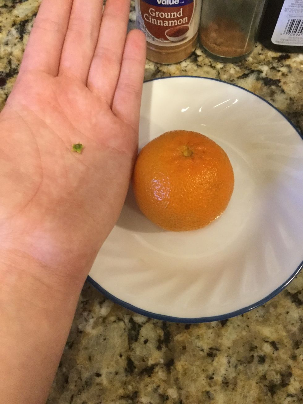 First take the green top off of the orange like so