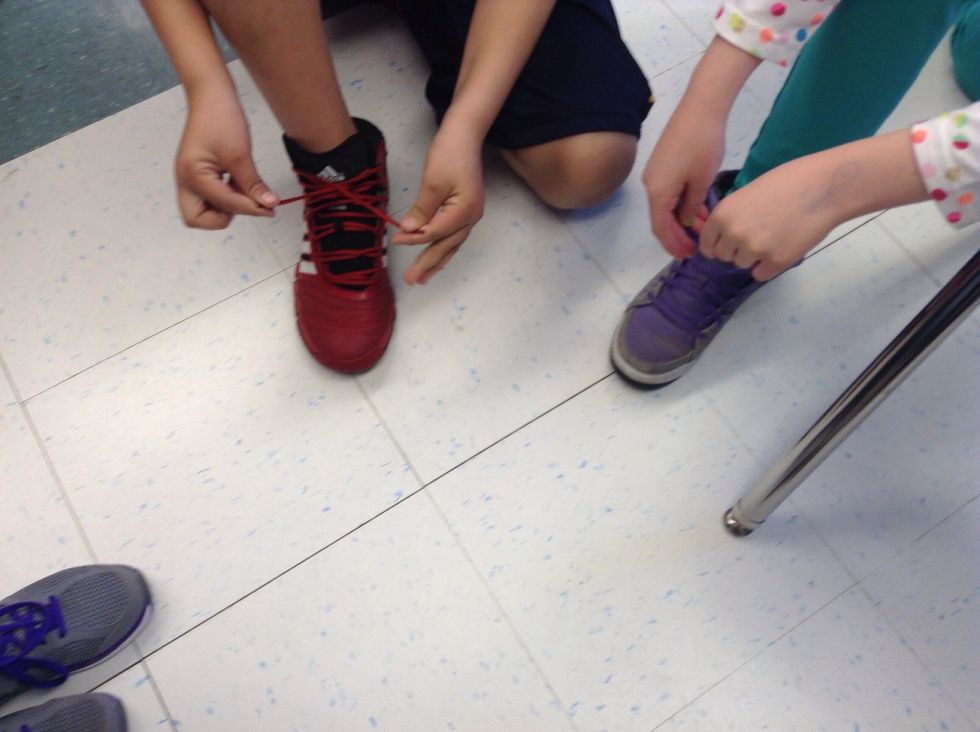 First take the left and the right laces and cross them.