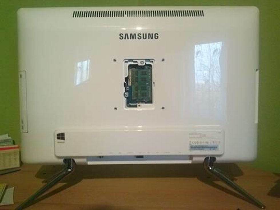 First take to panel off the back and undo the screw underneath. Lay the computer face down on a soft cloth with the legs overhanging the edge of the surface.