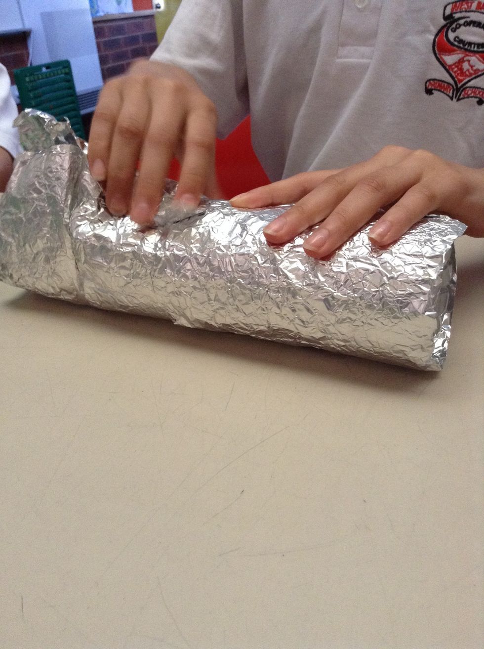 First, take your bottle and cover it in the aluminium foil.