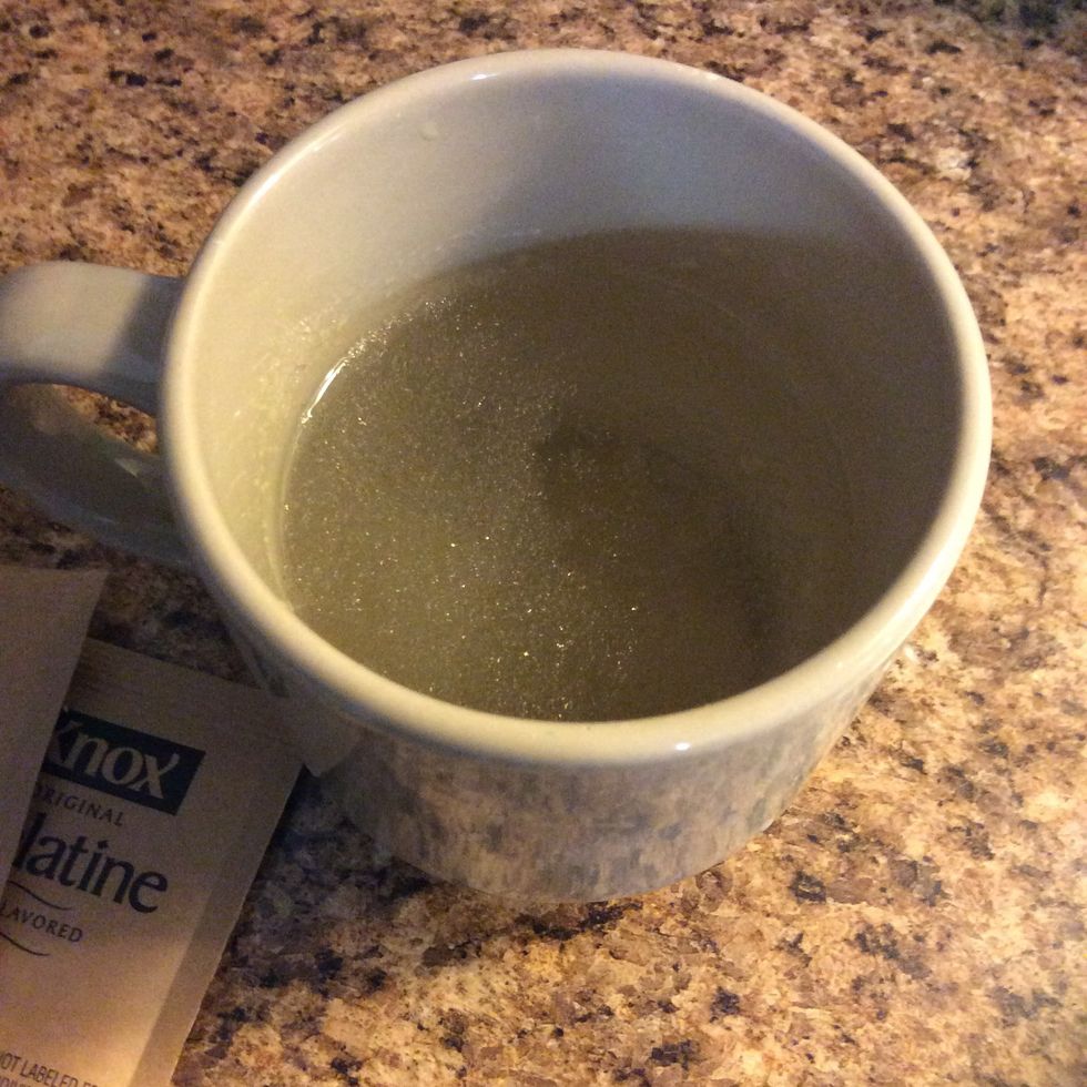 First thing we want t do after greasing our pan is to add 1 cup of water into a coffee mug( use whatever you like). And we want to mix the unflavored gelatin into the water until well dissolved.