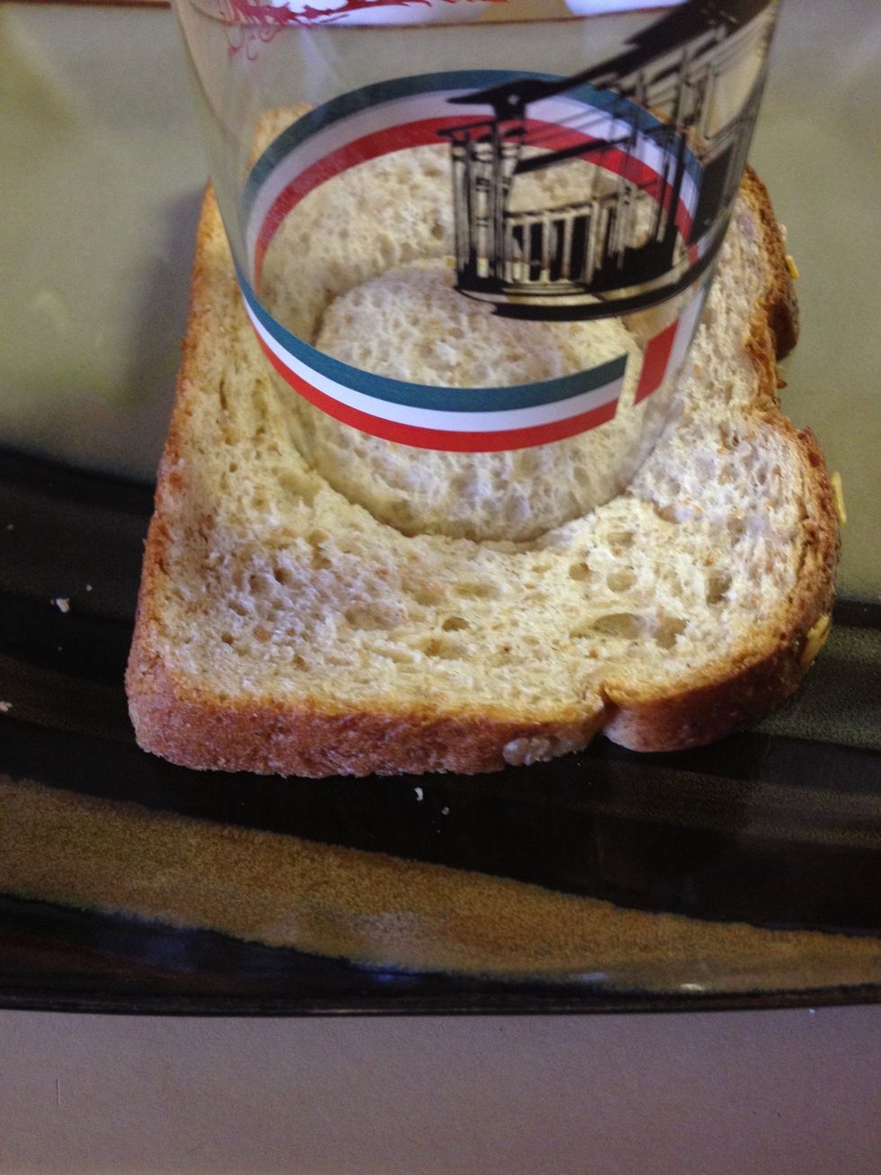 First, use your cup (or cookie cutter) to make a hole in your bread, I used a circular cup, but who said you couldn't use a zig-zag cookie cutter?