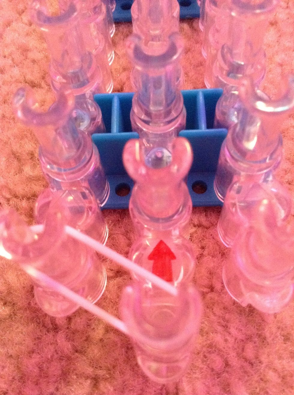 First we are doing our broader (the sides) place one rubber band on the left (or right) of the loom  TIP: make sure the arrow is points away from you.