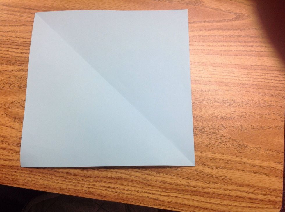 First we fold our paper, from one corner to the opposite corner, then do the same for the other two corners.