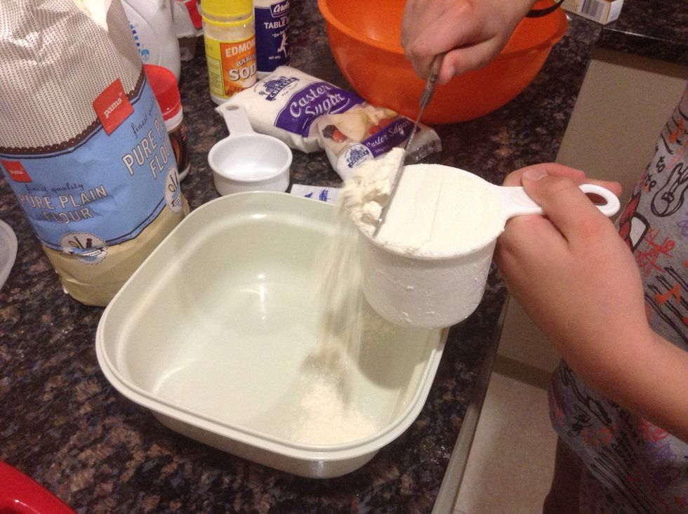 First we measured off the flour. We scraped it with the back of the knife and flopped it in the mixing bowl!