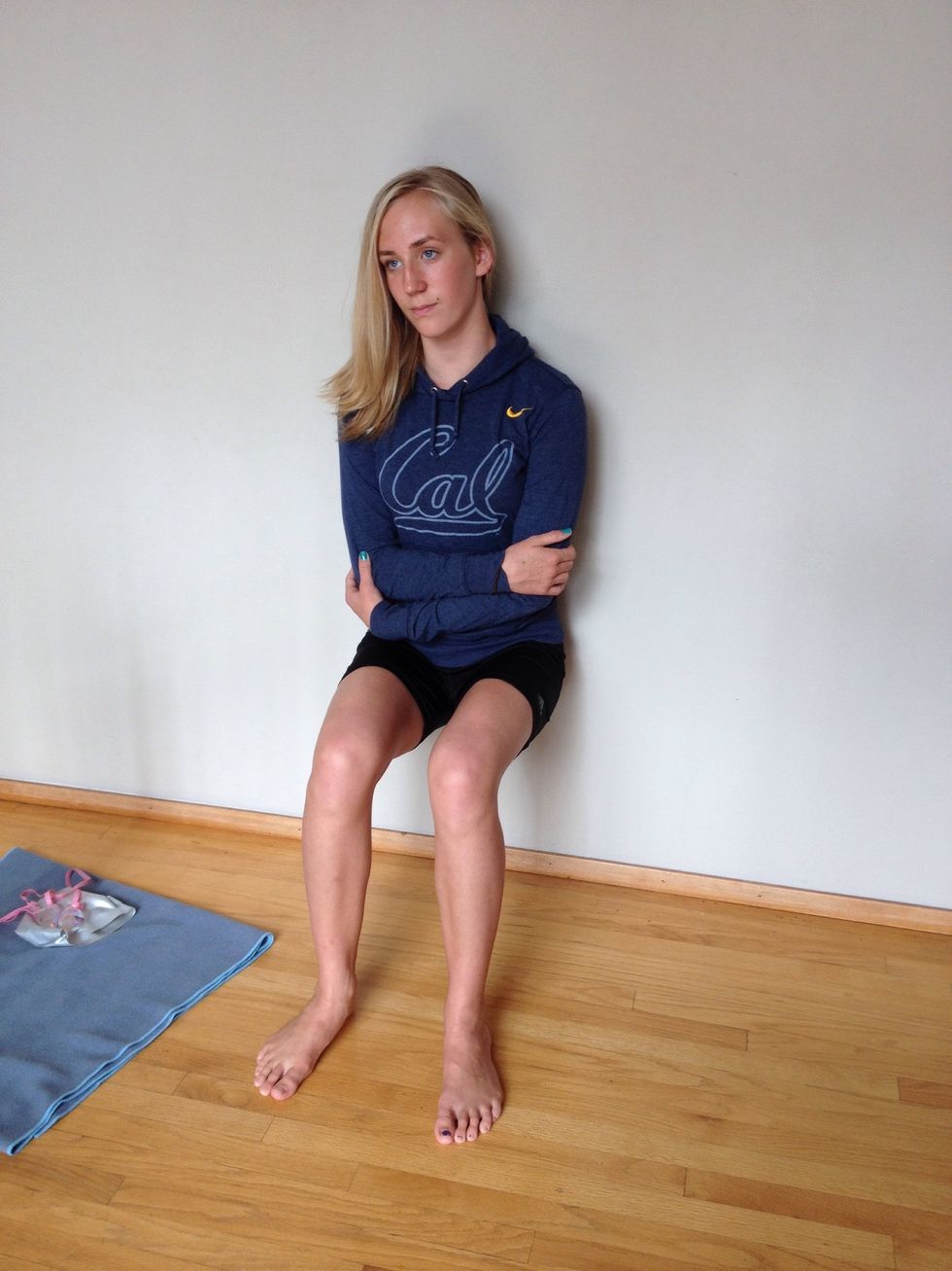 First we're going to start with wall sits. Make sure to hold your legs at a 90-degree angle and keep your hands off your quads. Try to hold this for a minute!