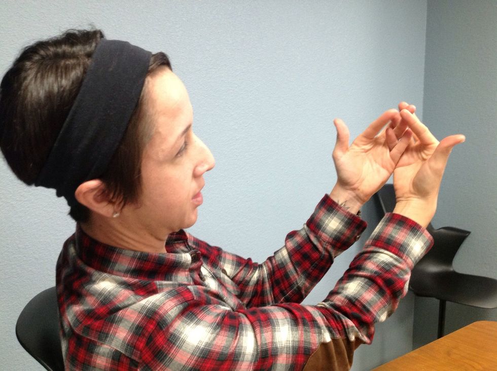 First, with both palms facing you, cross your pinky fingers.