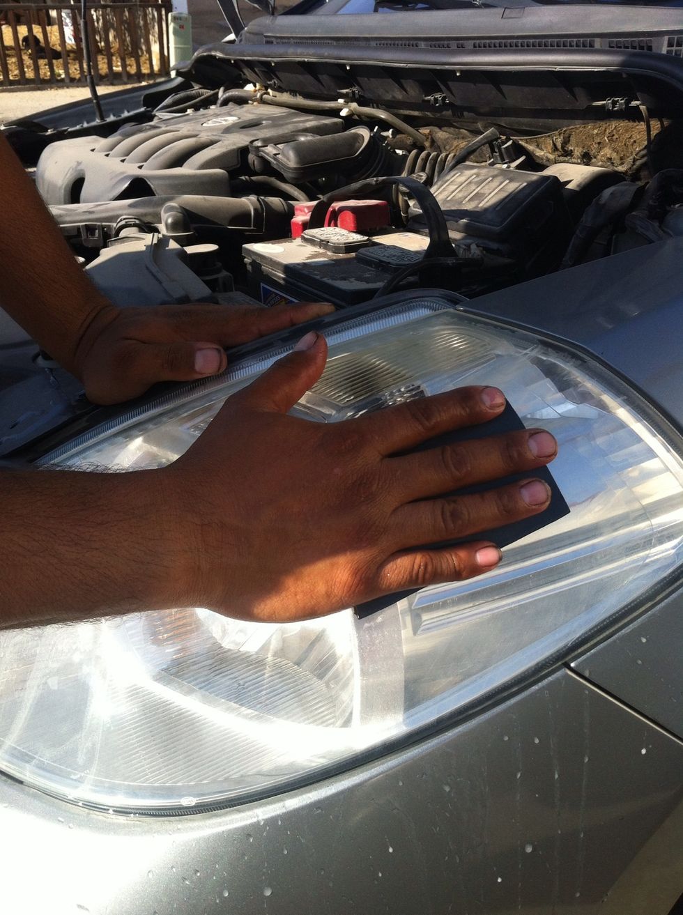 First you have to polish the headlights with your sandpaper adding water at the same time