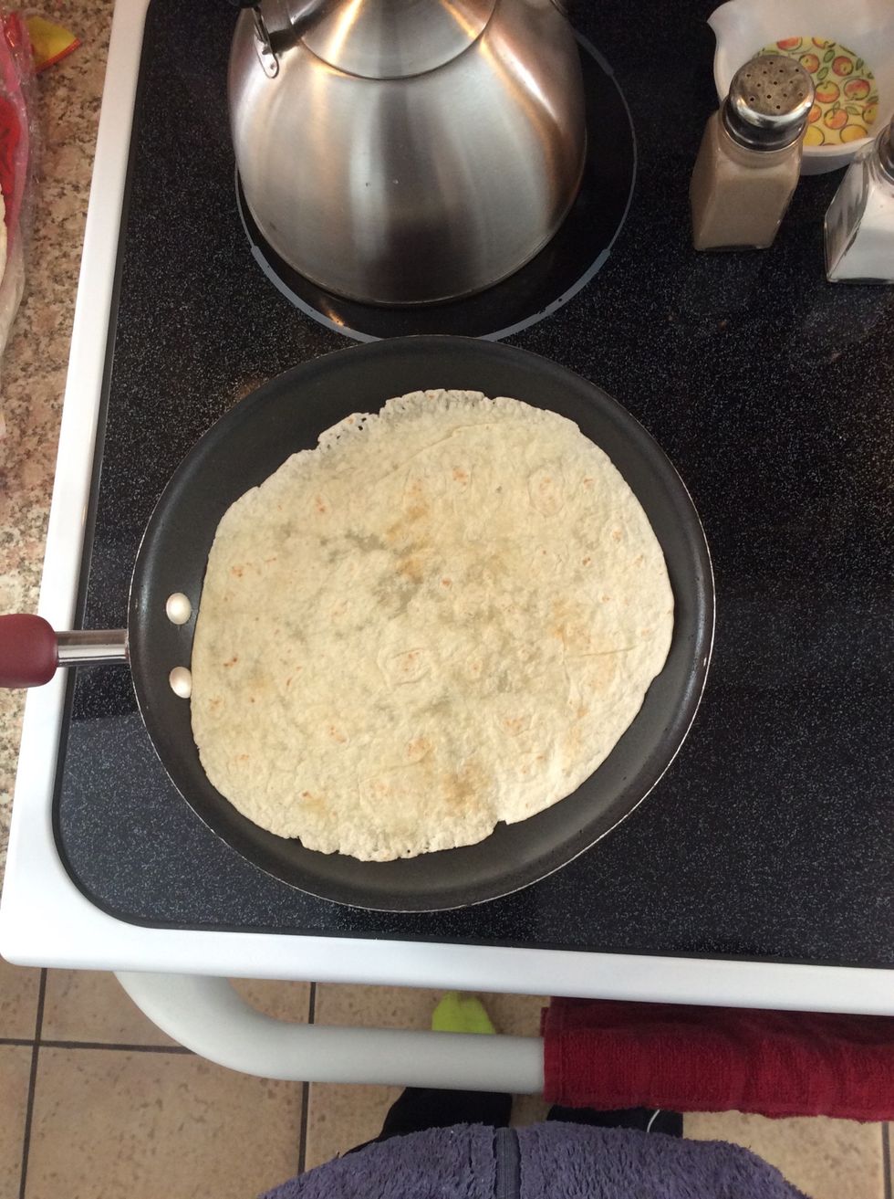First you heat up the bottom piece of the tortilla.