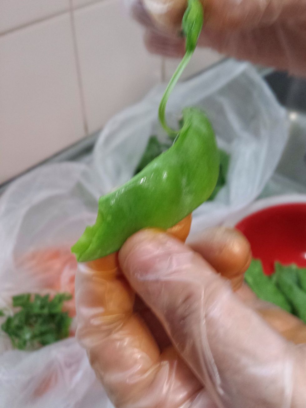 First, you need to peel the snow peas. You grab the stalk and pull down the flat side which should peel out a sting-like thing.