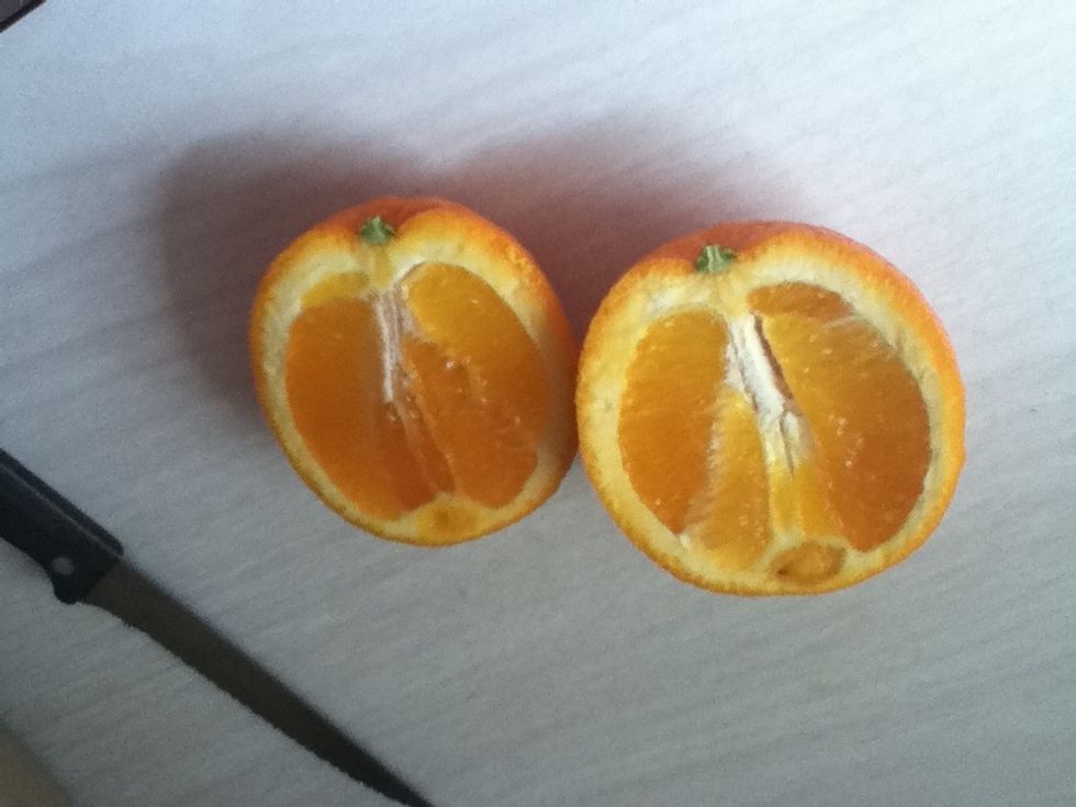 first you're going to cut the oranges in half, and scoop the inside of the oranges out.