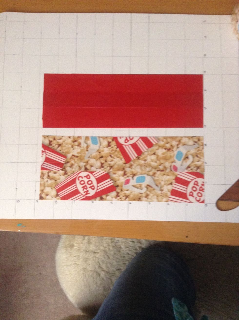 First you take a 9 inch duct tape piece and tape it on the board you will need 2 and make it 3 inches tall. Next you do the same thing with the pattern tape and make it 3.5 inches tall.