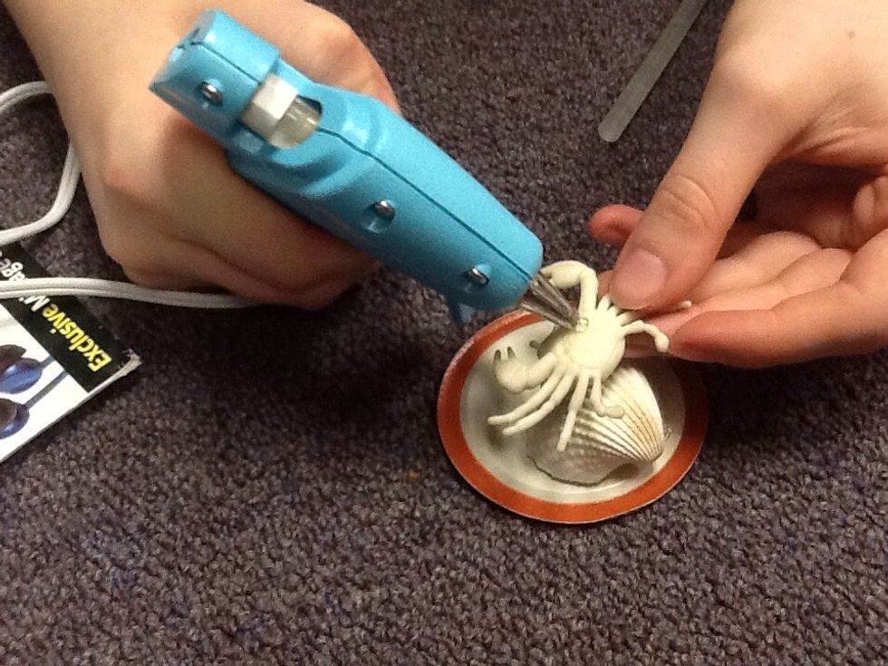 First you want to hot glue your figurine down on to the mason jar lid