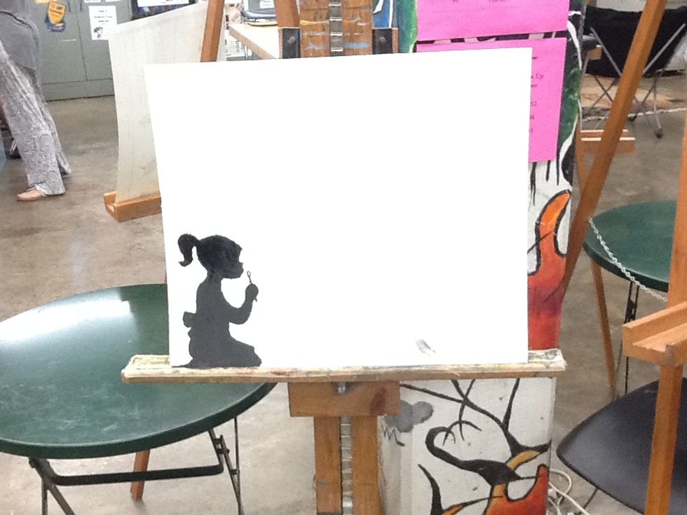 First you would trace the stencil of the person on the paper. Then, after you traced the stencil on you would paint in the stencil with black. Make sure the paint is dry.