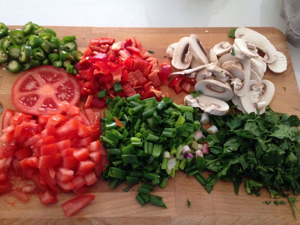 Firstly clean and chop 1 green and 1 red bell pepper, 5 mushrooms (middle out) 4 spring onions, 1 large tomato and a handful of parsley