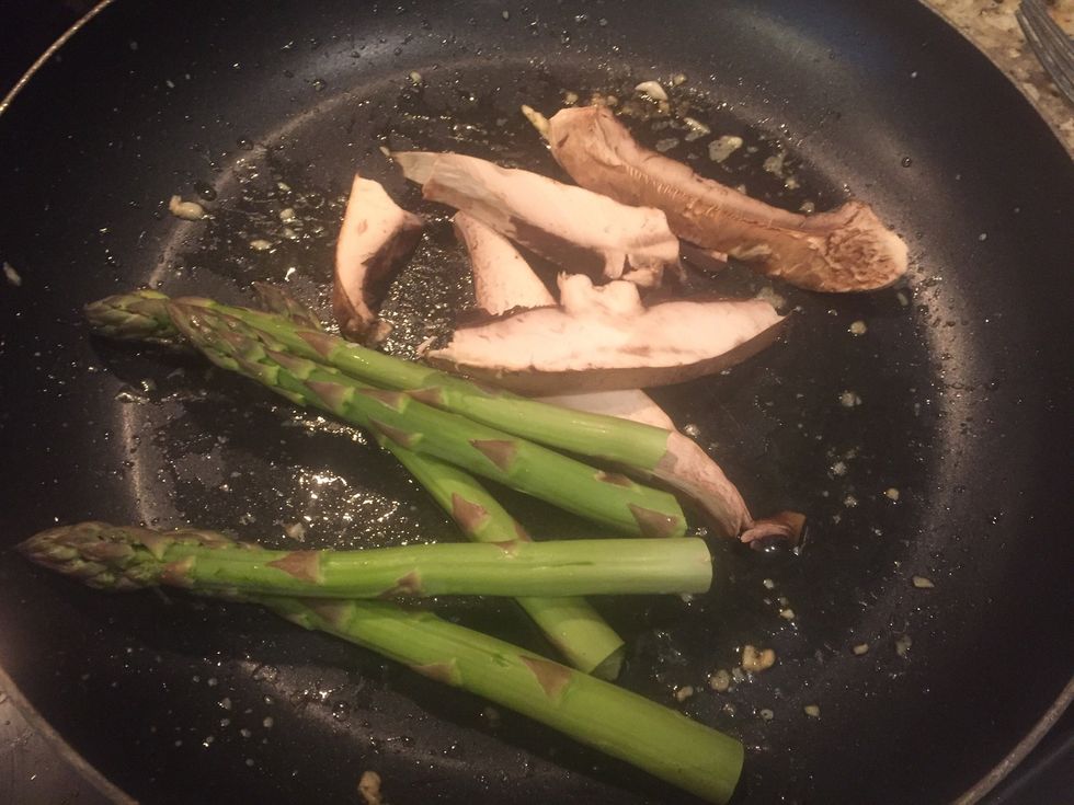 Fish should be done now! Remove from pan and put on a plate. Put a little more oil in the pan and add in mushrooms and asparagus, as peppers tend to cook pretty quick.