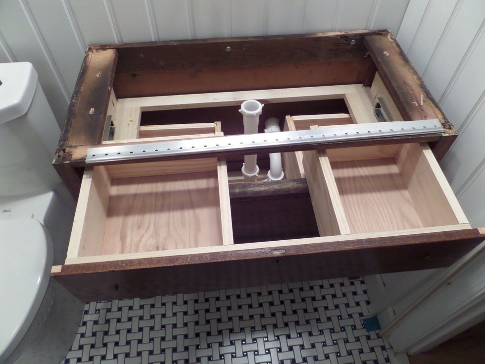 Fit the cabinet in place securing it to the wall and attach the top.