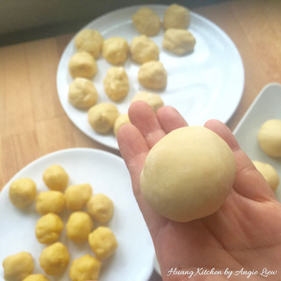 Flatten each piece of WATER dough into a flat circle. Place a piece of OIL dough in the centre. Gather edges of WATER dough to enclose OIL dough. Repeat the same for the rest of the WATER & OIL dough.