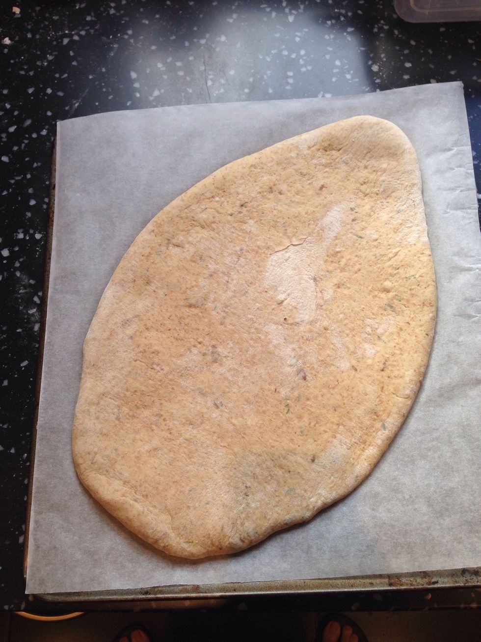 Flatten out the dough and use a rolling pin to smooth out into an oval shape. Place this onto a sheet of greaseproof baking paper and cover with cling film until height doubles. Preheat oven to 230\u00b0c