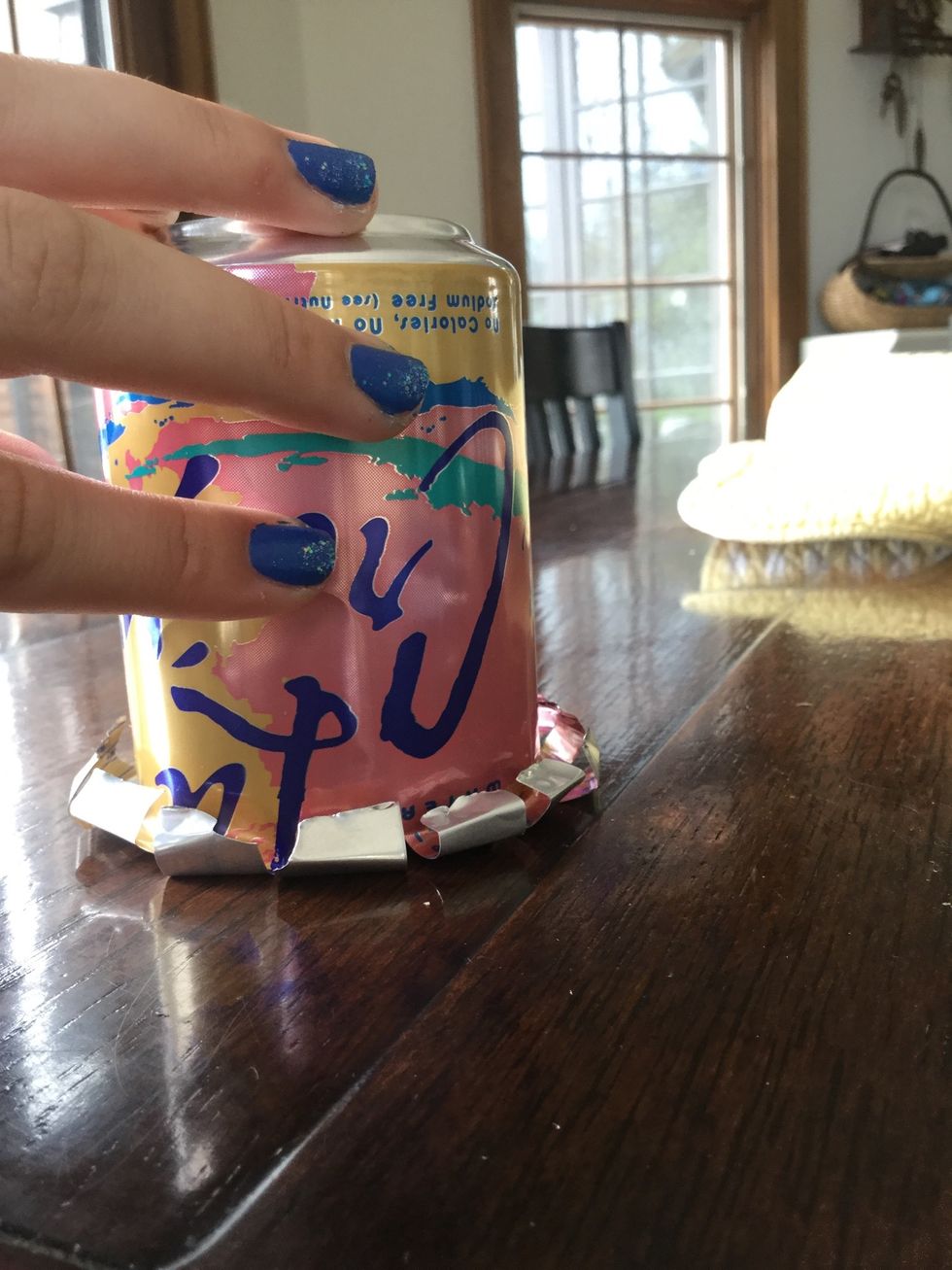 Flatten out the top by pushing down on a flat surface. This will make the top neater and less sharp. Then dry the can out with paper towel or tissue.