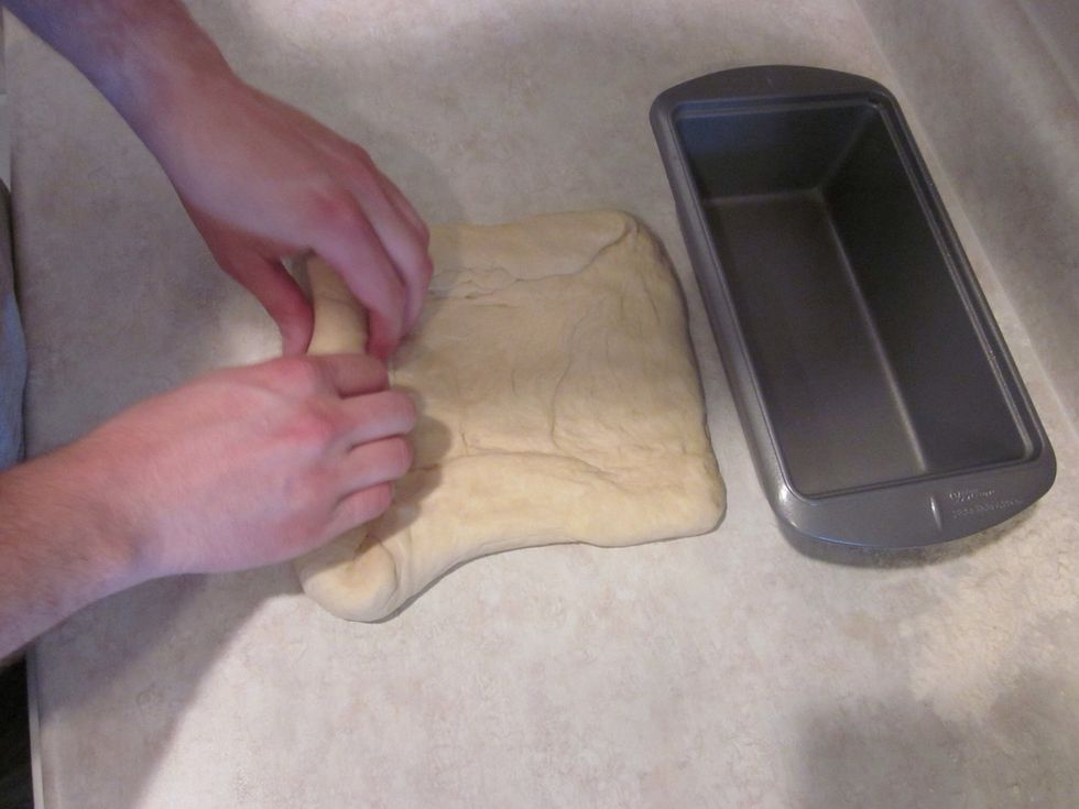 Flatten the dough out to be the length of your pan and about twice as wide. Roll it up in a tight roll.