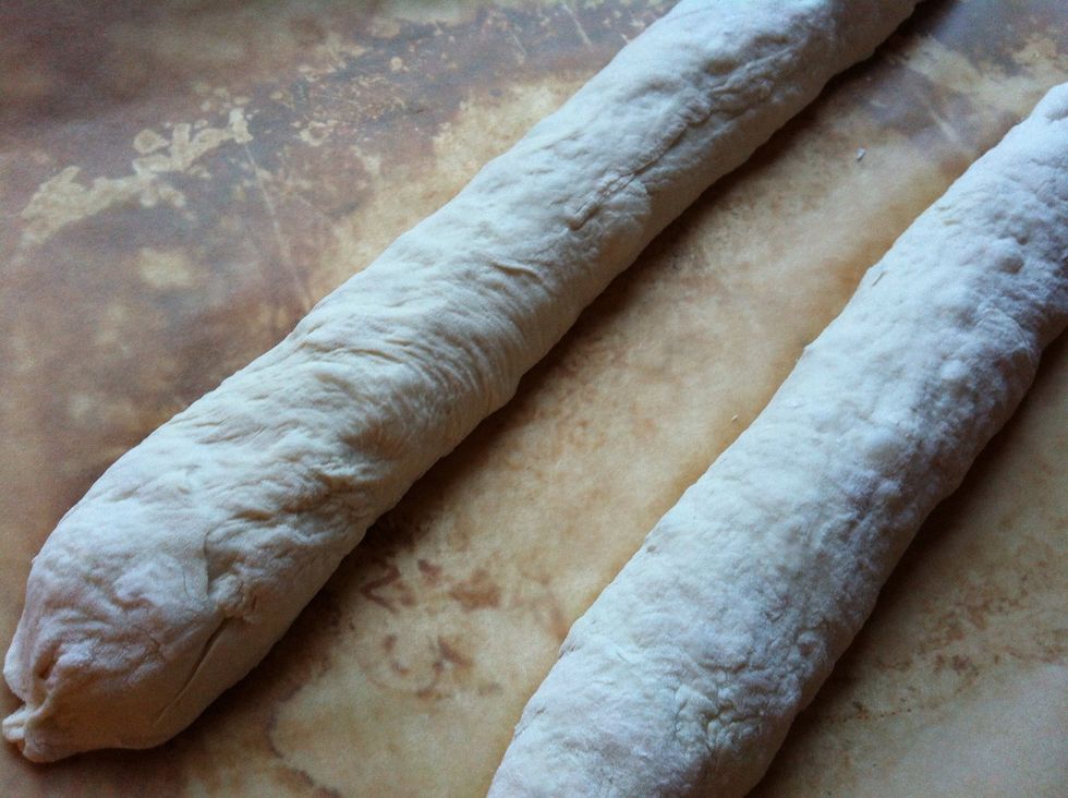 Flatten the dough to an oval and fold it twice. Do it with each piece of dough and put them on a baking sheet. Cover them with plastic wrap and leave them alone for another 1.5 hours.