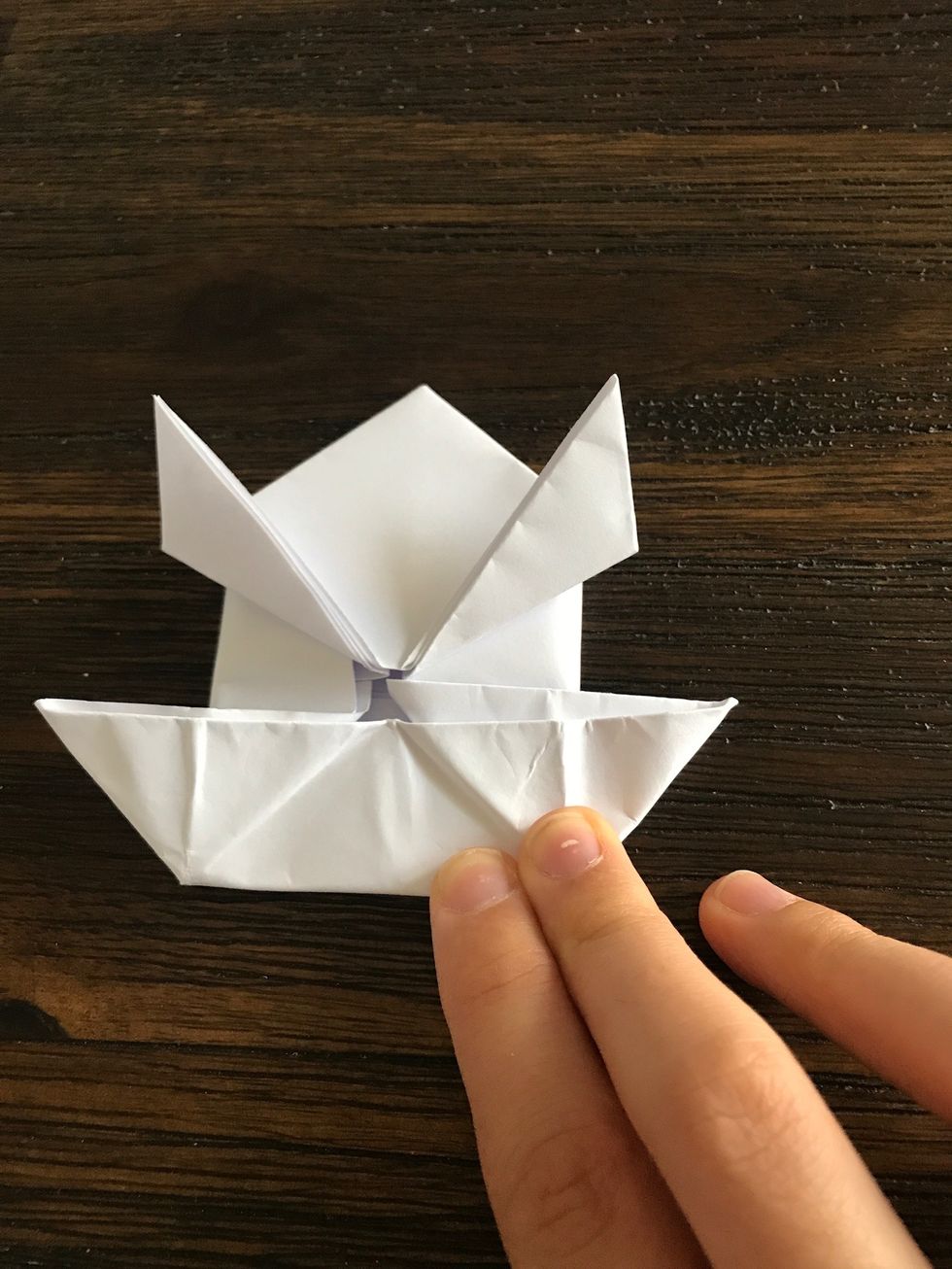Flatten the paper to make a boat shape.