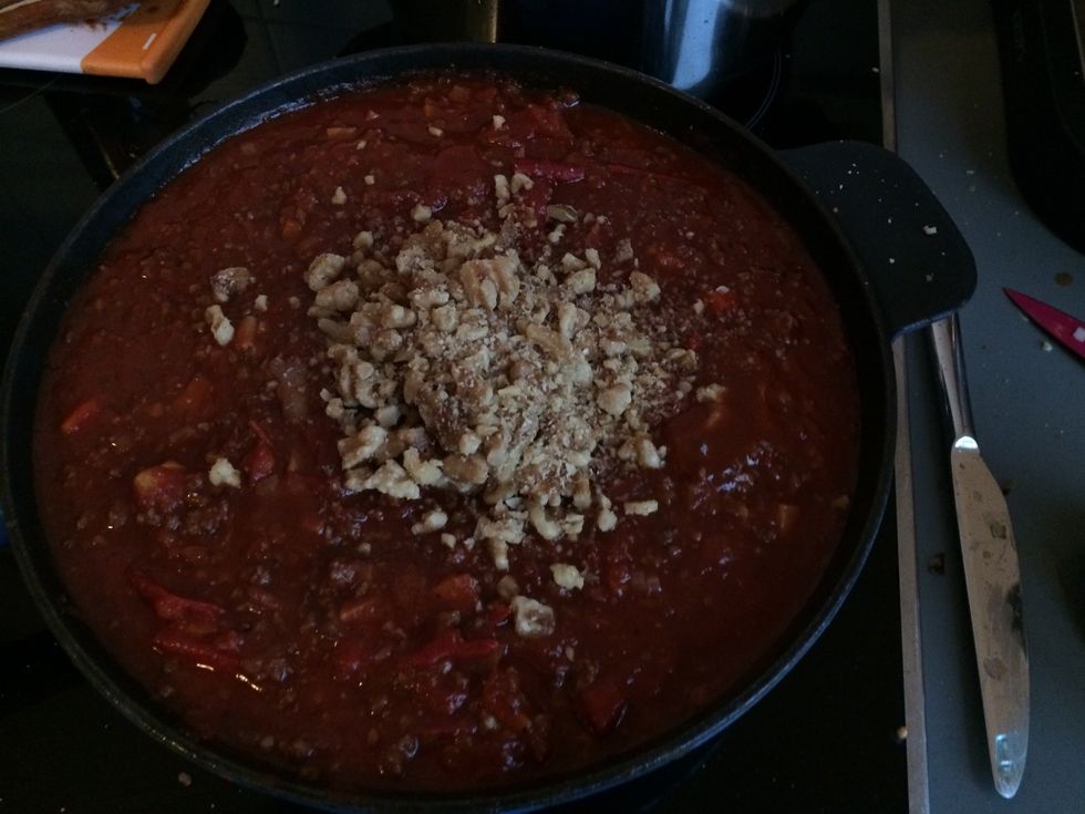 Fleisch zur Tomatenso\u00dfe geben. Dann auf niedriger Stufe k\u00f6cheln lassen und wenn es zu dick wird mit Rotwein und passierten Tomaten verl\u00e4ngern. Gegen Ende Waln\u00fcsse, gehackt dazu (optional)