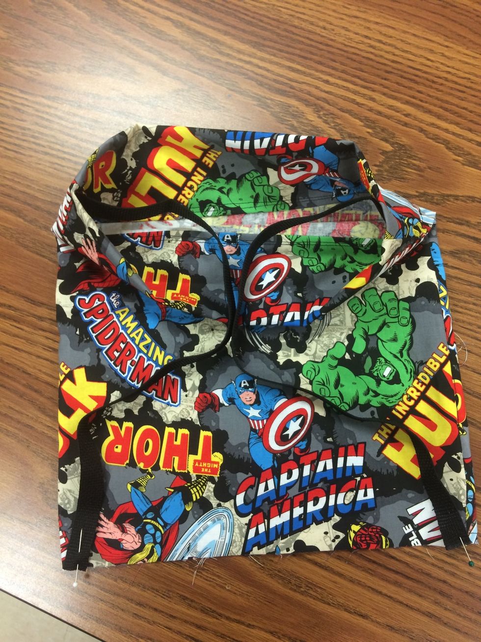 Flip bag right side out. Step 12. Be sure straps are not twisted. Line up outer edge of strap to the bottom line and pin as shown