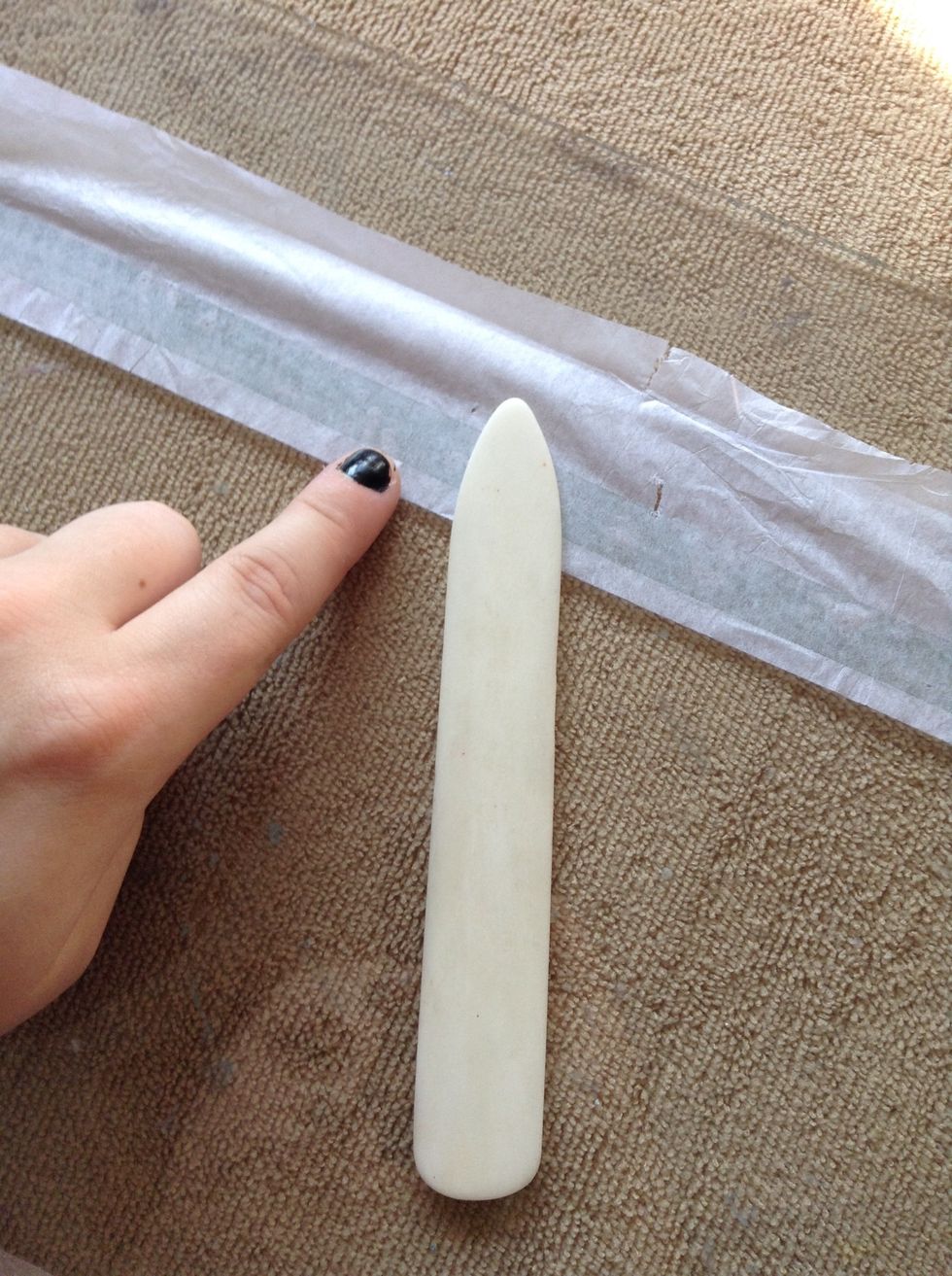 Flip over the tissue paper with the tape facing down. Use your bone folder to apply pressure so that the tissue paper will stick better to the tape