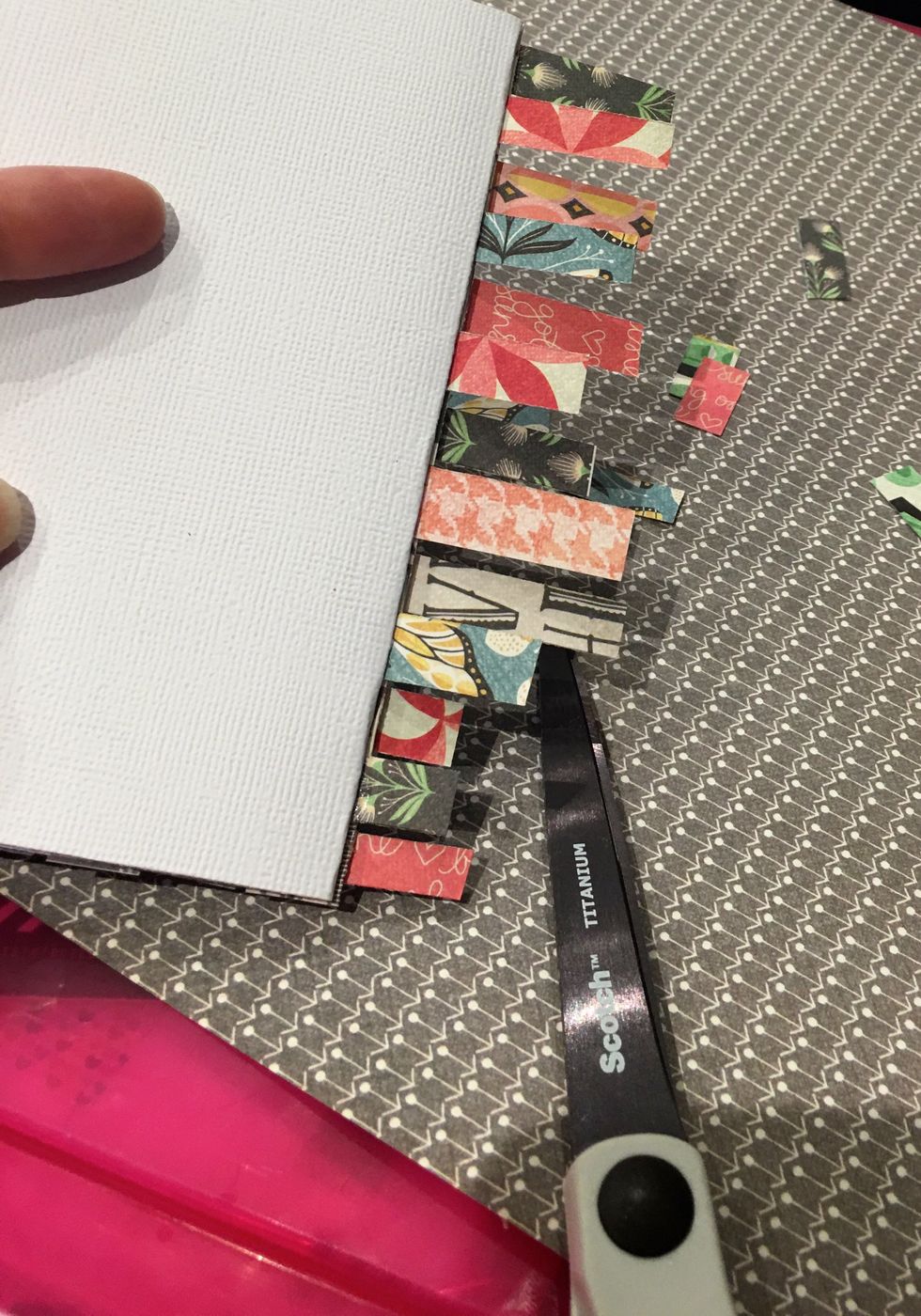 Flip the card over and cleanly trim off the excess paper strips, using scissors and following the edge of the white cardstock.