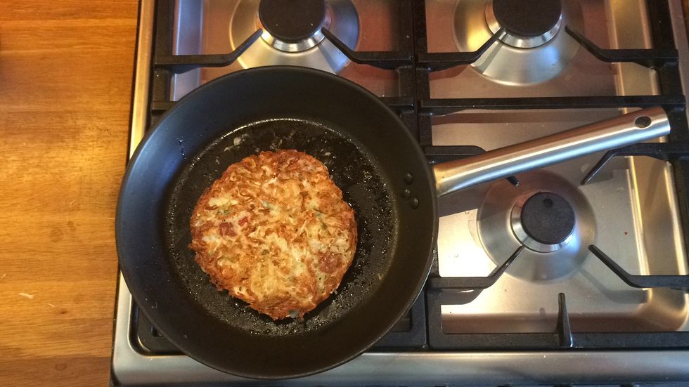 Flip the okonomiyaki and add a little more oil to the pan. The cooked surface should be golden. Very lightly press down on the okonomiyaki to ensure the base is flat and cook until golden.