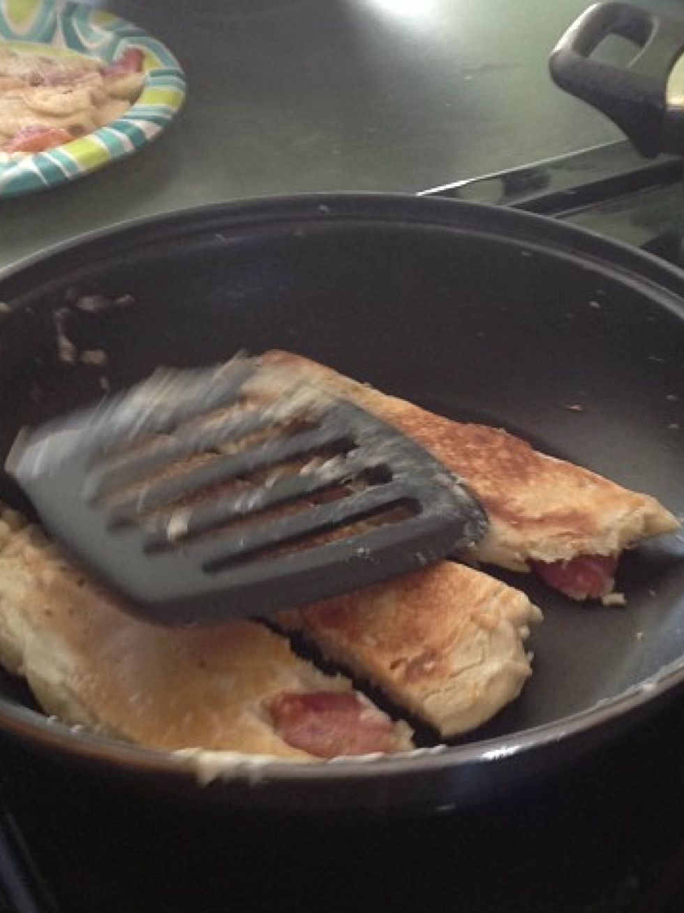 Flip the pancake after its cooked enough. Slice the pancakes into strips around the bacon so there is bacon in each pancake strip.