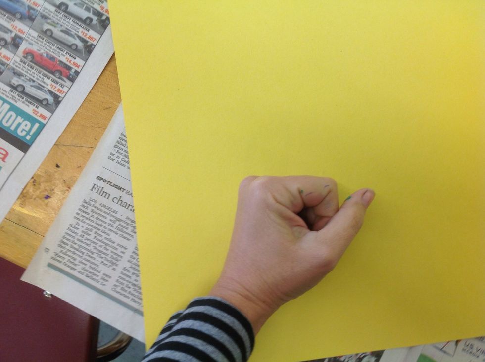 Flip the paper and the plate together on a clean newspaper so that you can see your name. Use your fist to evenly rub the area where the printing plate is.